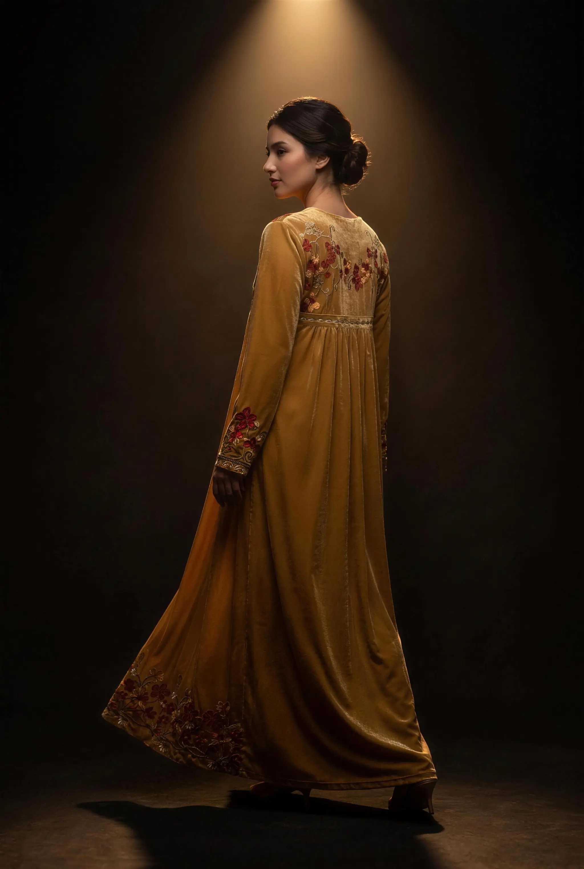 Femme portant la robe longue Orient Gold Prestige de la boutique, lumière dorée dramatique